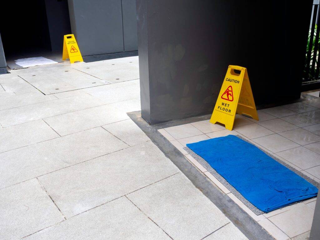 A public area with a Caution Sign and non-slip floor mat for added safety