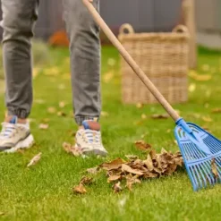 male-feet-lawn-rake-near-leaves